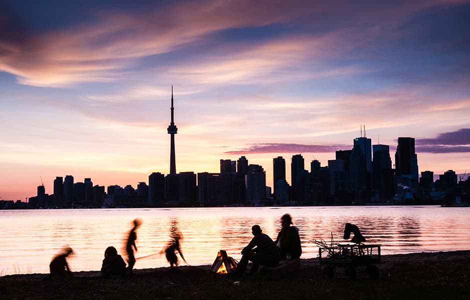 family picnic on shore with toronto skyline backdrop at dusk canada