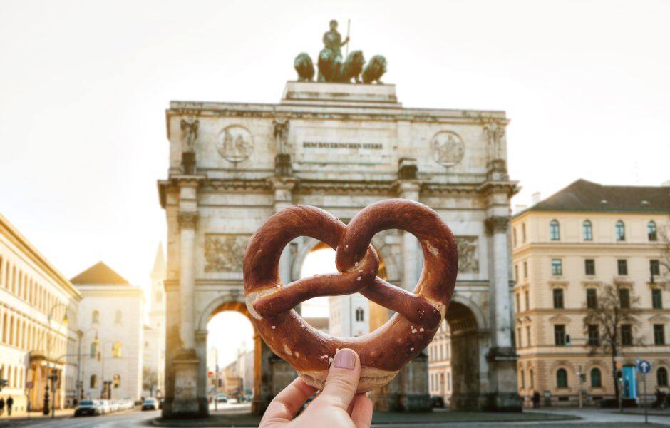 girl holding pretzel at the victoria gate arch siegestor in munich germany