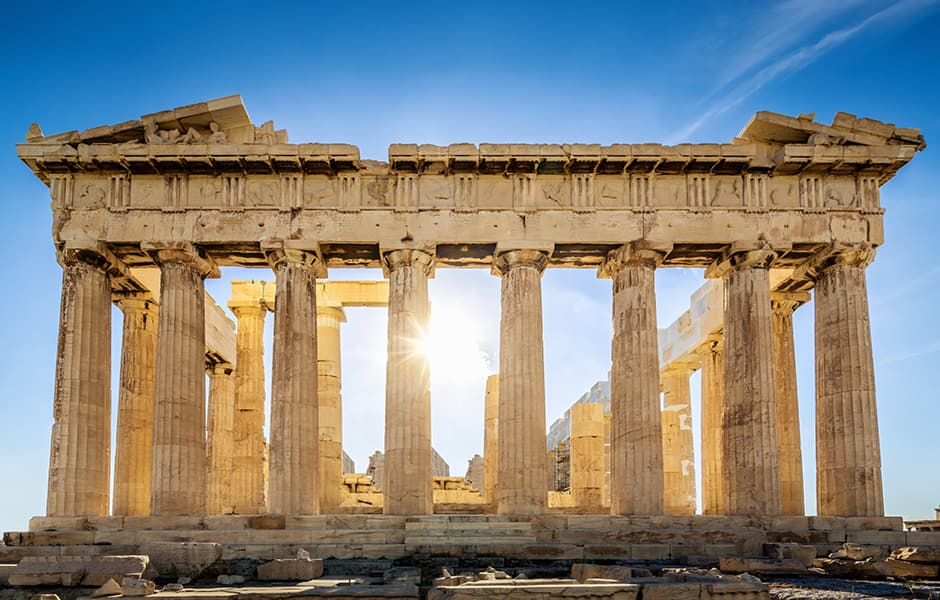 sun shining through the columns of the parthenon on the acropolis in athens