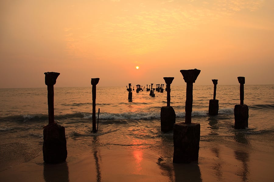 silhouettes of sea piers at sunset in calicutbeach india