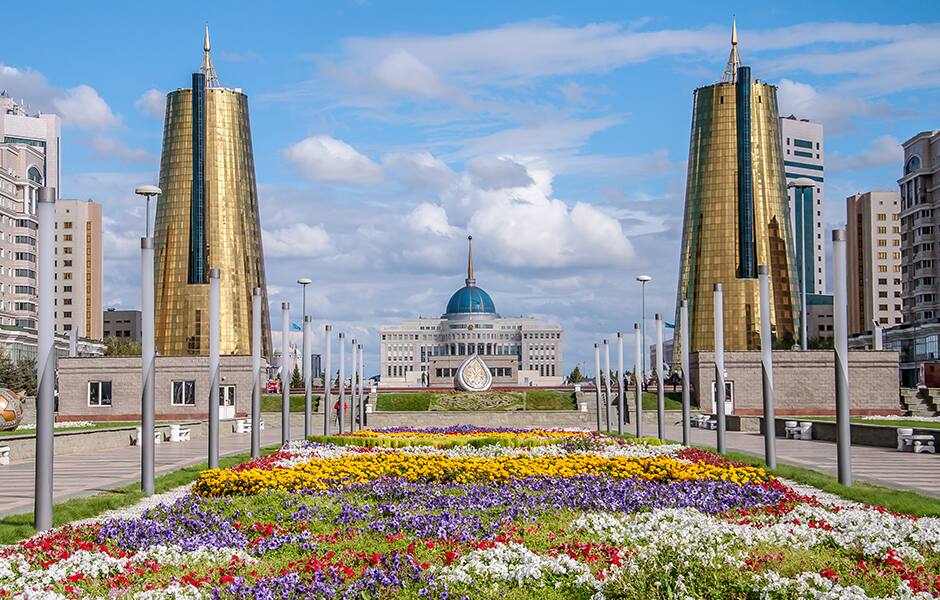 view of the transport tower and the khan shaty in the distance at night in astana