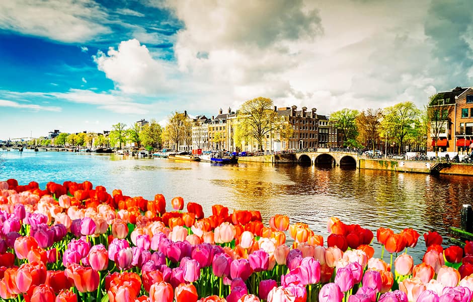 view of canal from bridge in amsterdam with dutch buildings