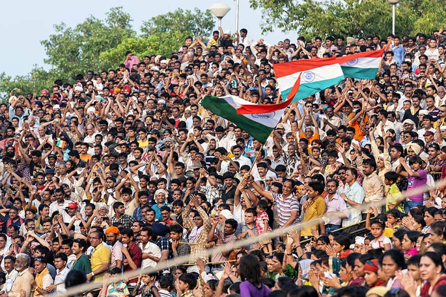 crowd shouting and waving flags during the ceremony at the wagah border lahore