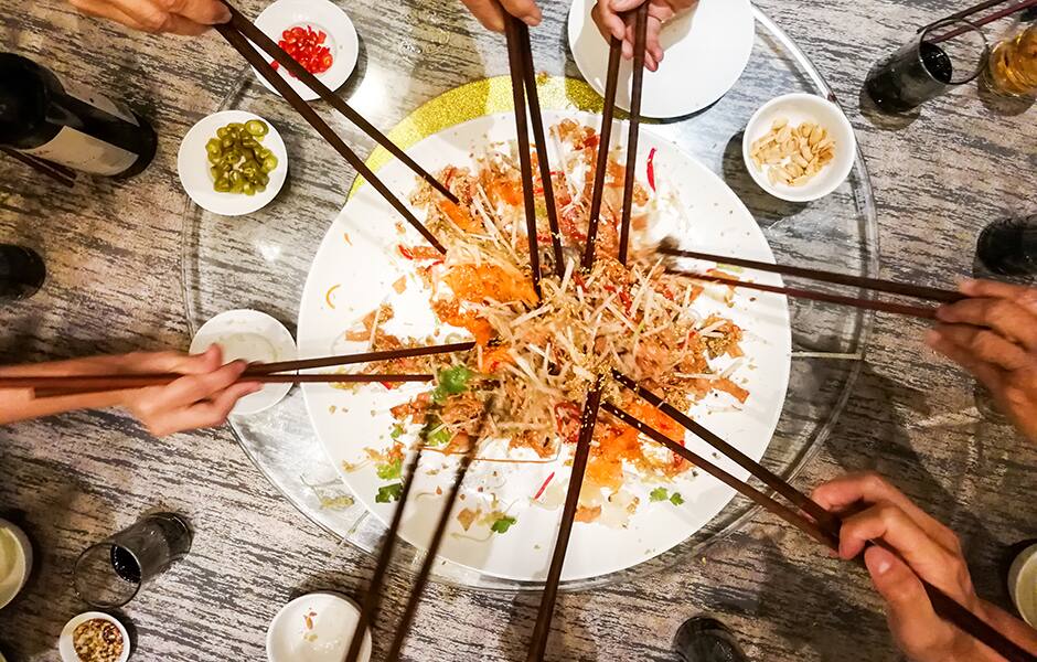 people tossing yee sang or yusheng during chinese new year singapore 