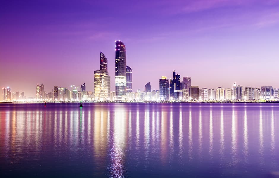 abu dhabi city skyline at twilight with reflection in the still sea uae 