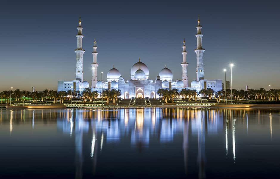 sheikh zayed mosque with reflections of building in water