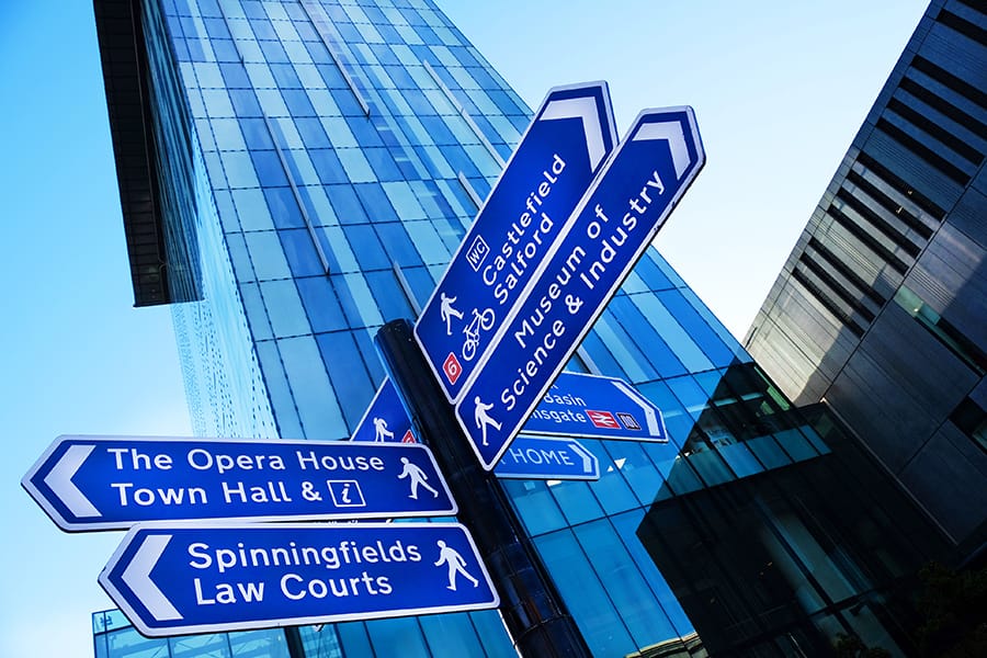 various blue street signs of manchester including sign for museum of science