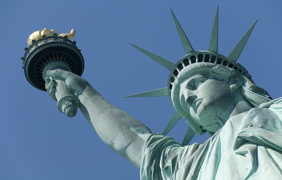 close up of the statue of liberty with a blue background in new york usa