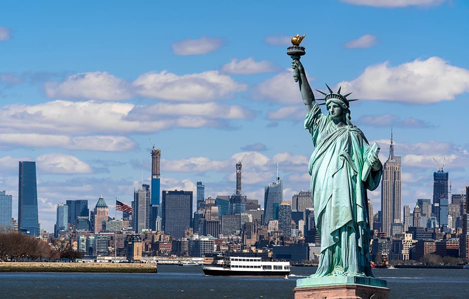 statue of liberty with manhattan lower east side in background